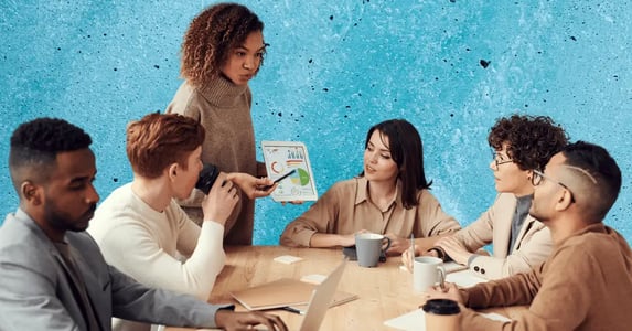 A diverse group of six young people sitting around a conference room table.